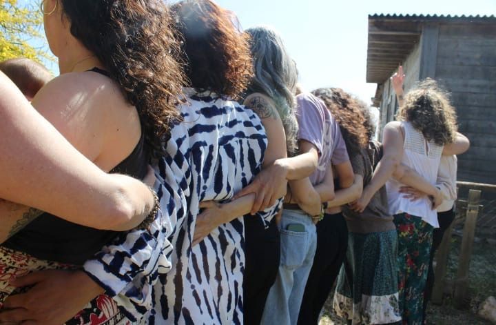 Alumnas abrazadas en fila, de espaldas